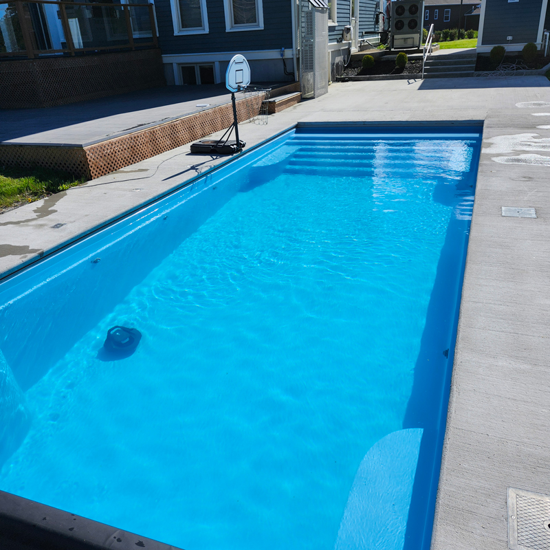 inground swimming pool with a basketball goal
